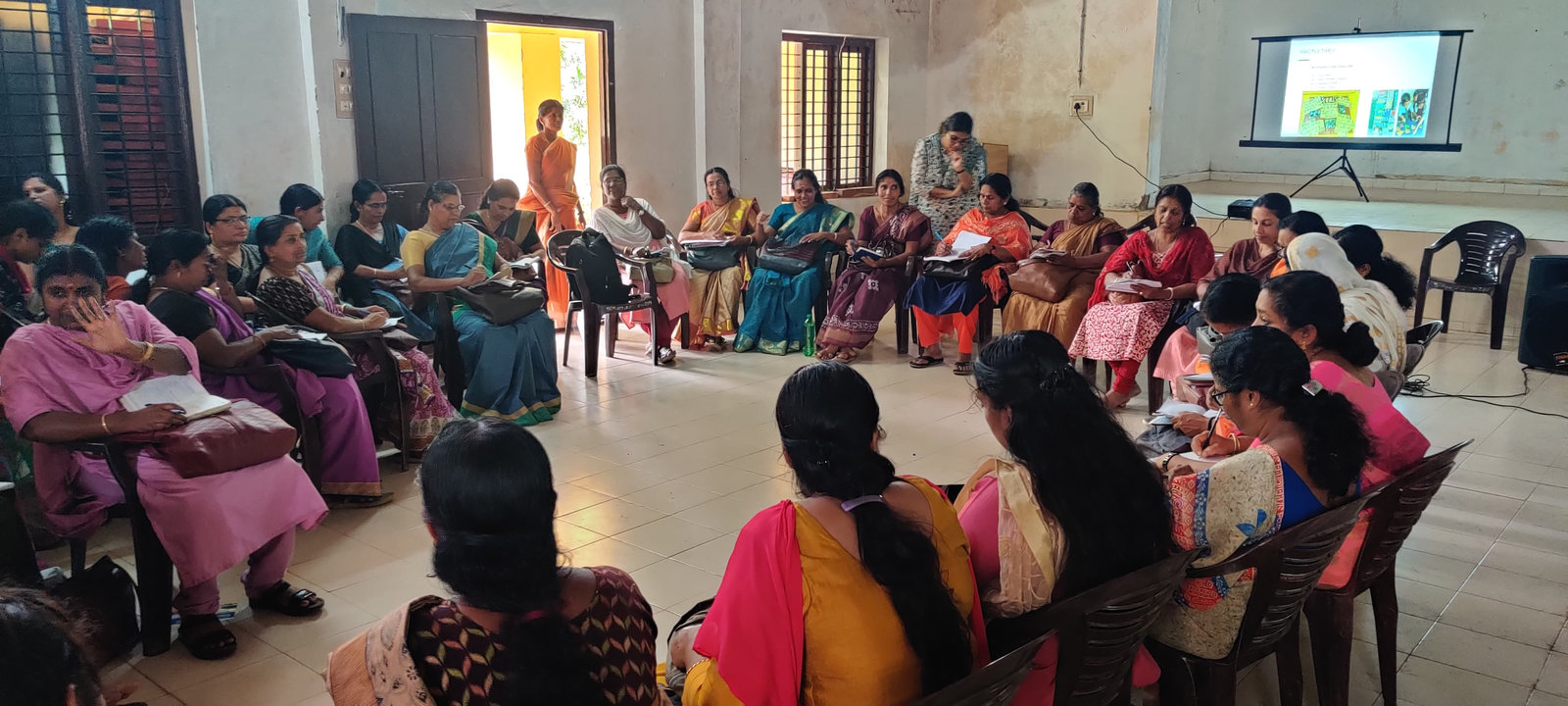 Anganwadi teachers seated in a circle during an activity