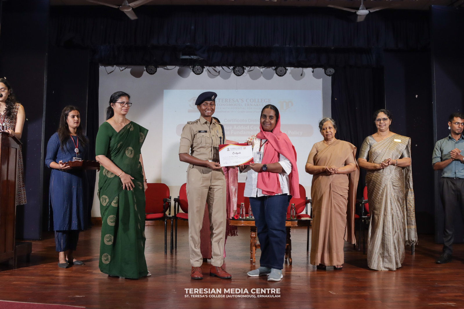A graduating student receives her certificate on stage at St. Teresa's College