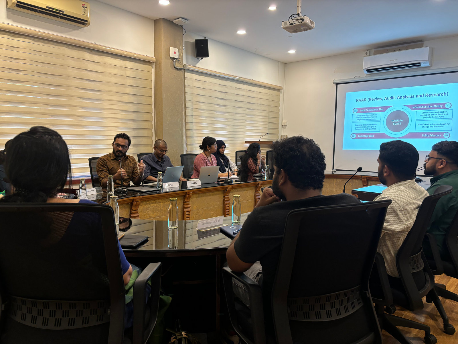 NPoC presents its RAAR (Review, Audit, Analysis and Research) framework to S.L.A.T.E partners around a conference table