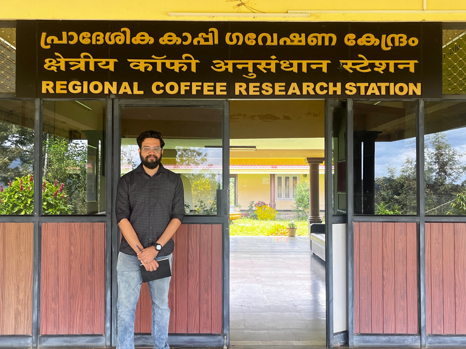 An NPoC team member outside the Regional Coffee Research Station, Chundale